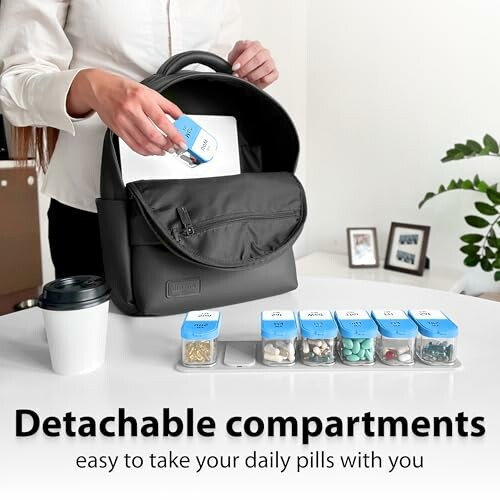 Person placing pill organizer in backpack with coffee cup nearby.