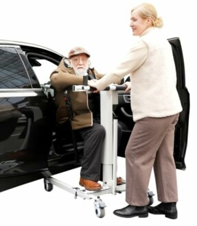 Person assisting elderly man with mobility aid from car.