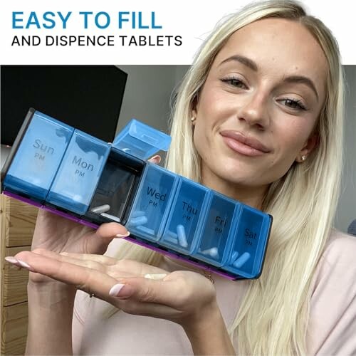 Woman holding a weekly pill organizer with labeled compartments.